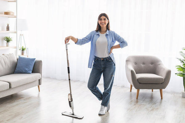 Broom, mop and floor scrub brush arranged for cleaning different surfaces