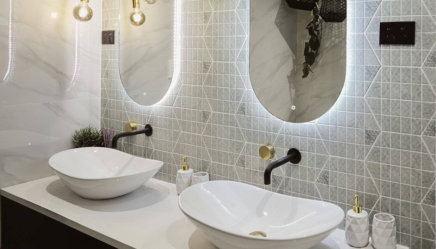Matte black wall-mounted basin tapware with brushed brass controls in a double-basin bathroom