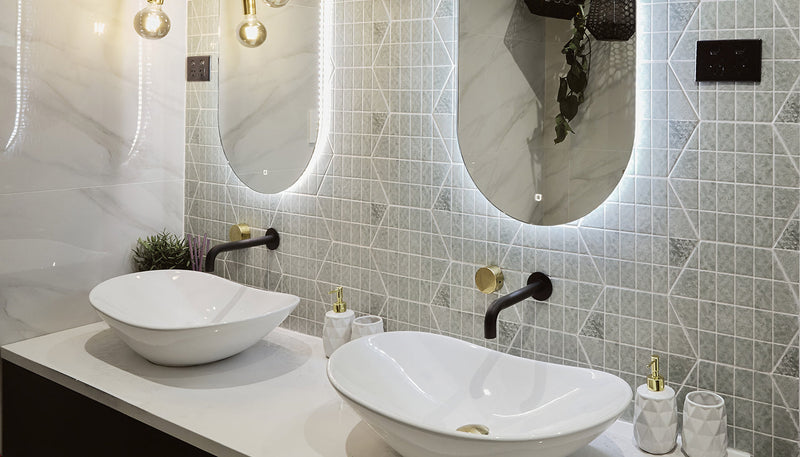Matte black wall-mounted basin tapware with brushed brass controls in a double-basin bathroom