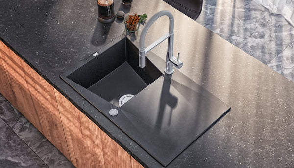 Granite kitchen sink being cleaned to maintain its finish