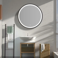 Load image into Gallery viewer, Bathroom interior with a round illuminated mirror, sink, and towel rack.
