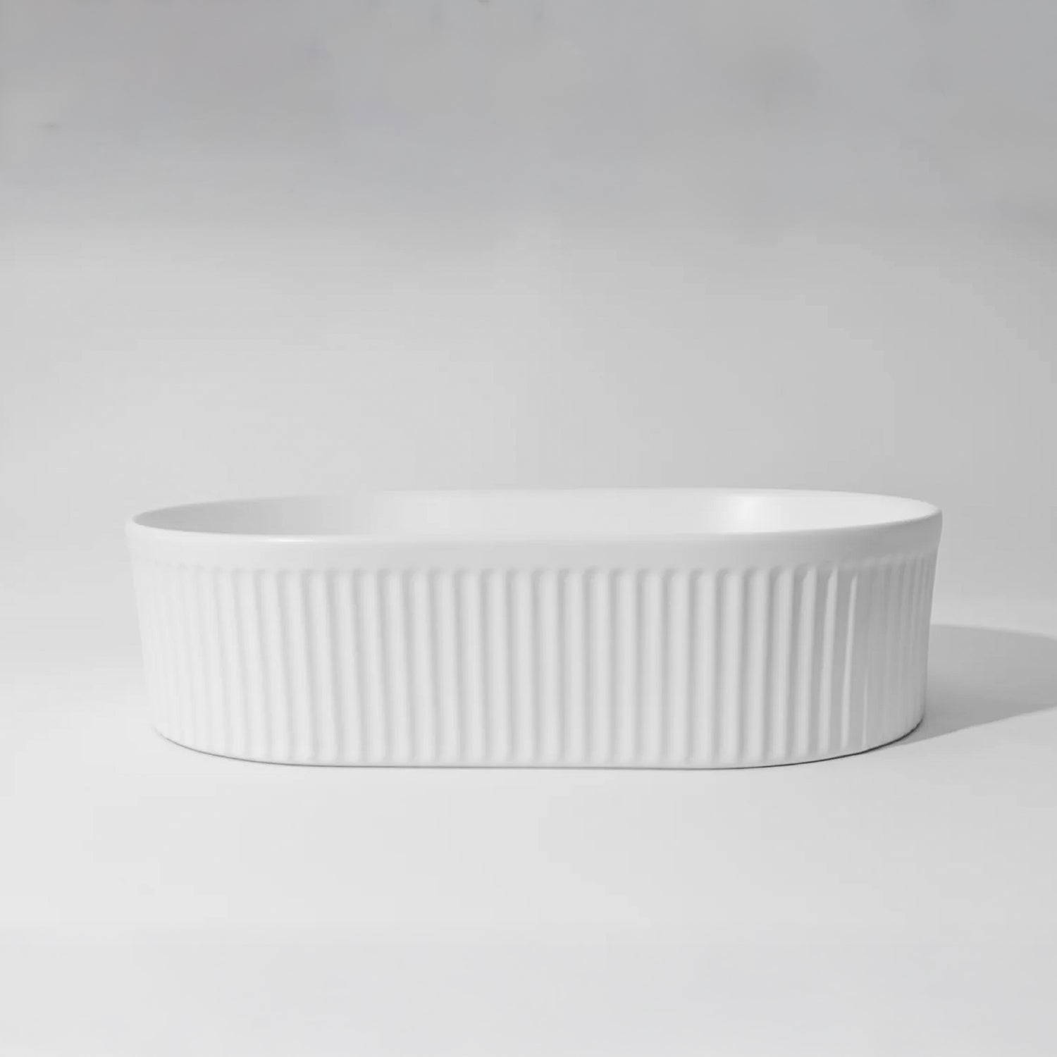 CLAYA Pill-49 fluted above counter basin in matte white ceramic. 490mm oval basin with vertical fluting and overflow for modern bathrooms.-Basin Sink-Ezymall AU
