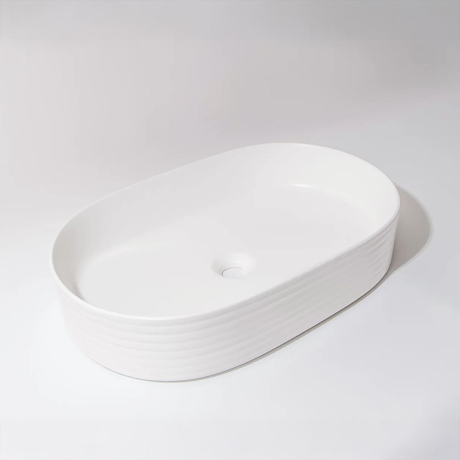 CLAYA Pill-60 fluted above counter basin in matte white ceramic. 605mm oval basin with non-overflow waste for modern bathroom vanities.-Basin Sink-Ezymall AU
