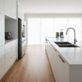 Load image into Gallery viewer, A double-basin undermount kitchen sink in a dark brushed stainless steel finish, in a white modern kitchen
